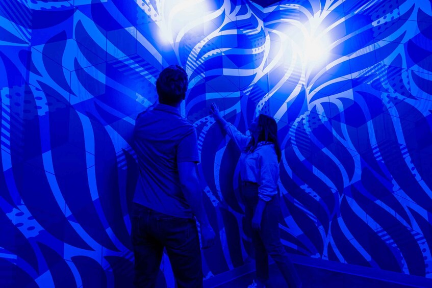 Two people looking at a blue light display. 1