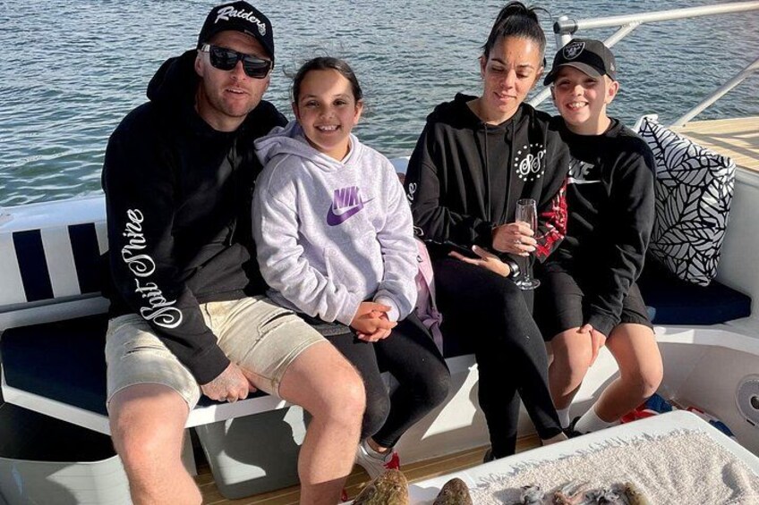 Four people on a boat with water in the background. 3