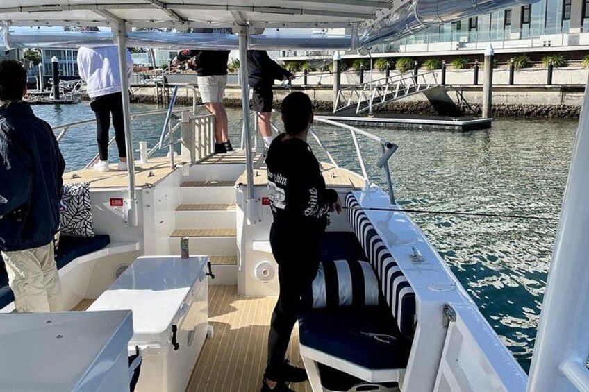 A boat with people on deck, a dock in the background, and water. 5