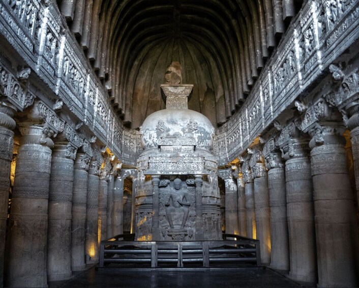 An ornate temple interior with detailed carvings and a central statue. 3