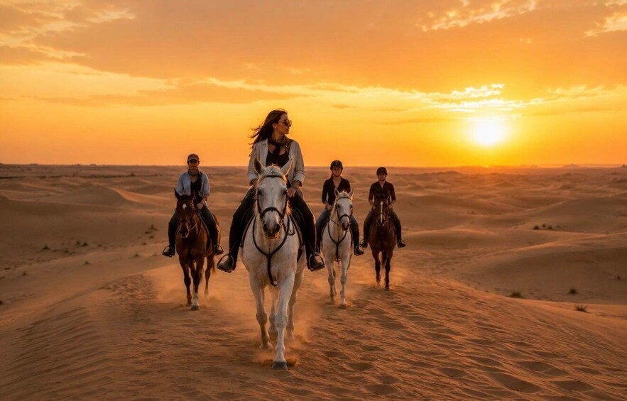 A group of people riding horses across a desert landscape during sunset. 1