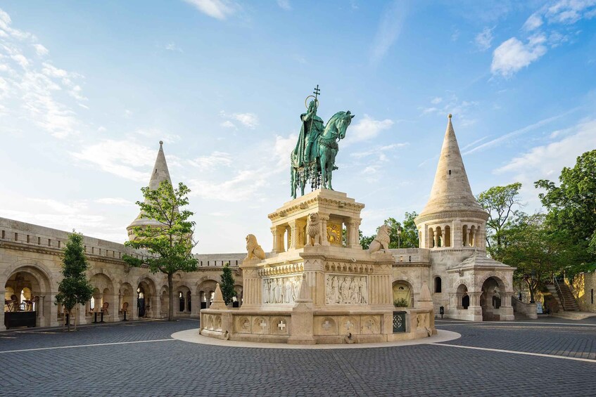 Ett historiskt torg med en central staty, två kupolformade byggnader och en detaljrikt utformad fontän. 2