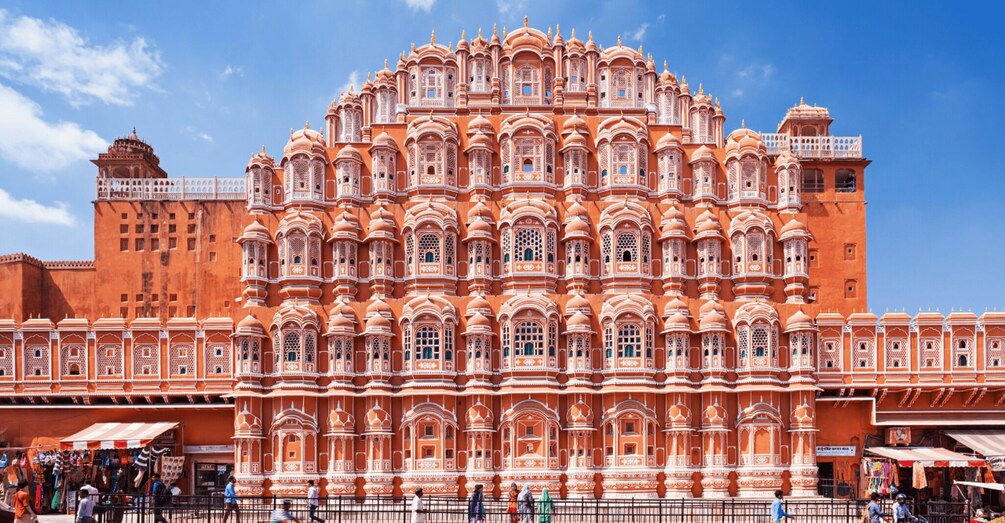 A large, ornate building with intricate architectural details and a clear blue sky in the background. 1