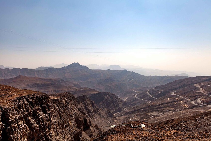 A rugged mountain landscape with winding roads and distant peaks. 4