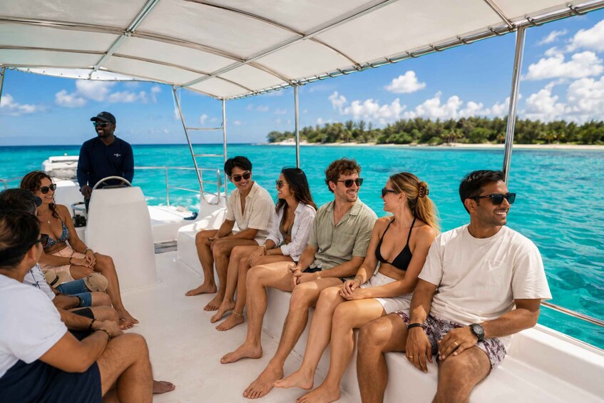 A group of people on a boat with a clear blue sea and a tropical island in the background. 2