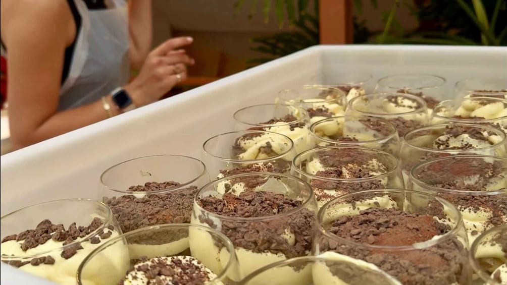 Una bandeja con copas de postre, cubiertas de chocolate y crema. 2