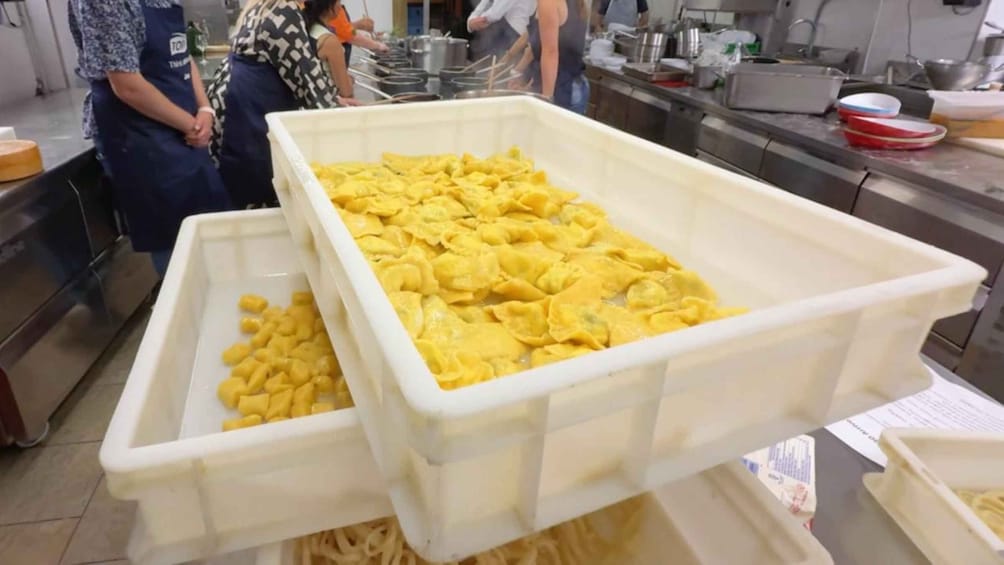 Una cocina con recipientes blancos grandes llenos de alimentos. 3