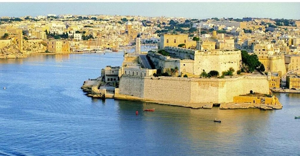 A fortified city with a prominent castle-like structure by the waterfront. 4