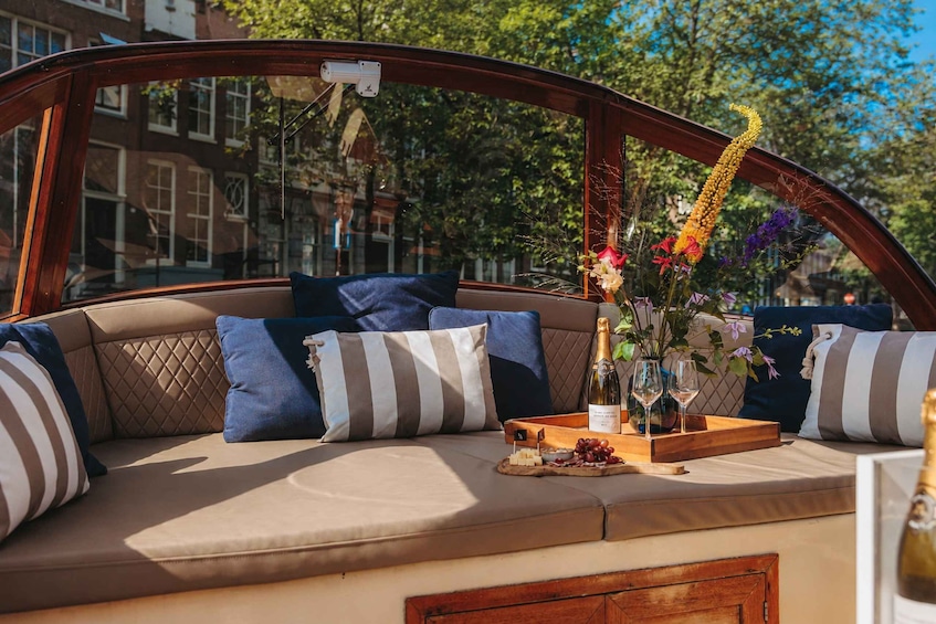 A cozy seating area with striped cushions and a tray of snacks and drinks. 1