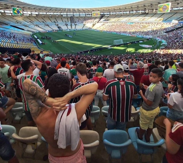 A crowded stadium with spectators and players in striped jerseys. 1