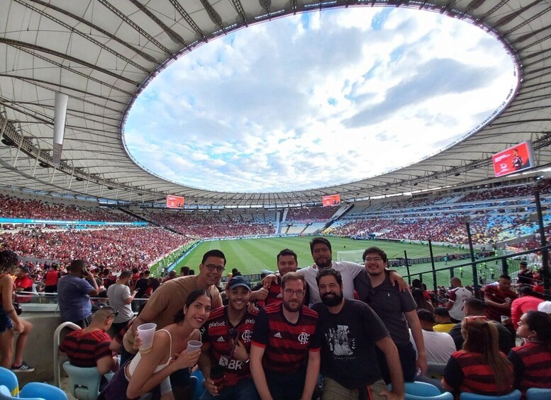 A stadium filled with spectators, a large circular roof, and a football field. 2