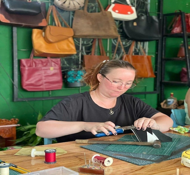 A person working with fabric and tools on a cutting mat. 4