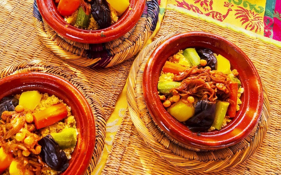 Three traditional Moroccan tagines filled with couscous, vegetables, and meat. 2