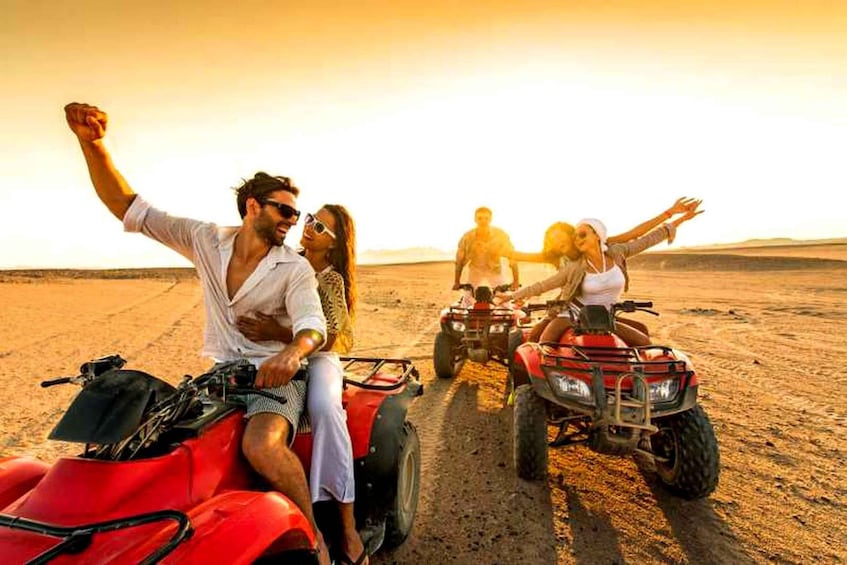 People riding ATVs on a dirt road in a desert landscape. 1