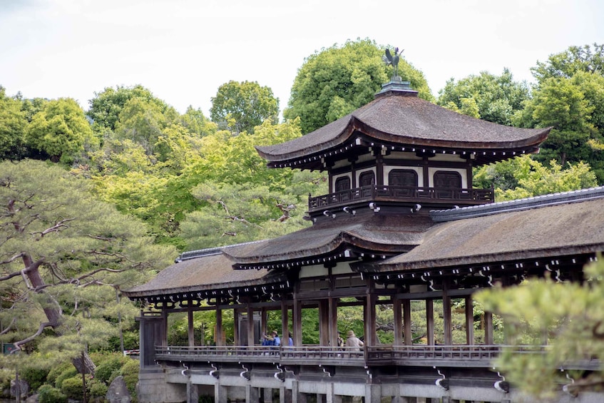 Une pagode japonaise traditionnelle, avec un toit de chaume, entourée d’une végétation luxuriante et d’arbres. 2