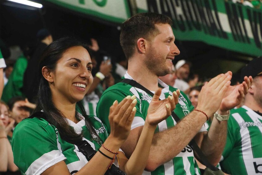 A crowd of people wearing green and white striped jerseys. 3