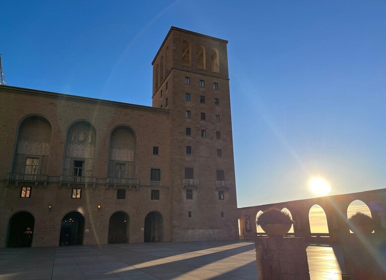 A historic building with arched windows and a tower, under a clear sky. 5