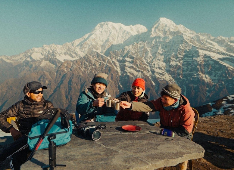 Four people sitting at a table with a mountain range in the background. 3