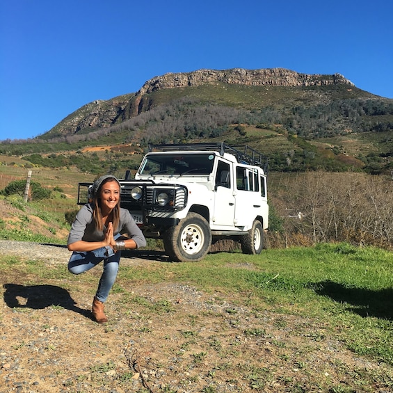A white off-road vehicle parked on a gravel path with a mountainous landscape in the background. 5