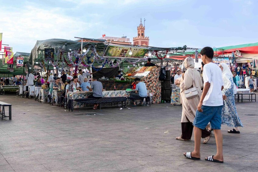 A bustling outdoor market with various stalls and people shopping. 5