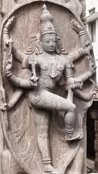 A stone sculpture of a deity with multiple arms, intricate carvings, and a headdress. 3