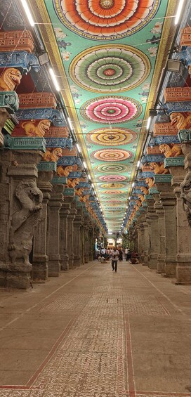 A corridor with ornate ceiling artwork and lion statues. 5