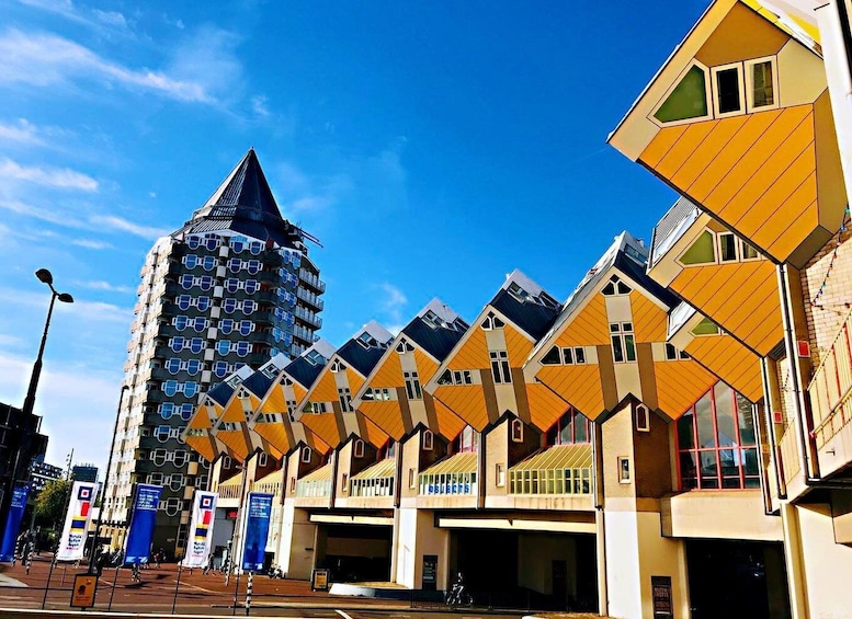 A modern building with a unique geometric design, featuring a series of yellow and brown facades with angular shapes. 2