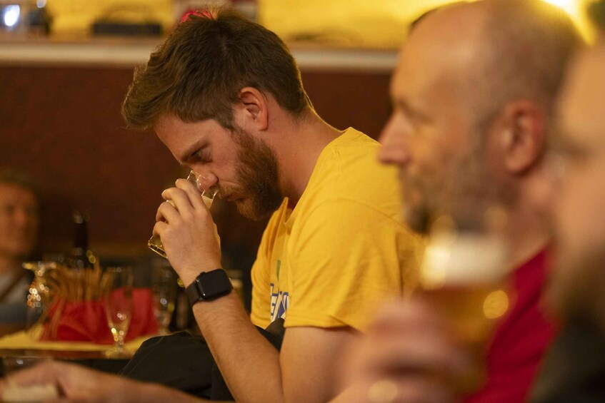 Une personne portant un t-shirt jaune et tenant un verre de vin. 1