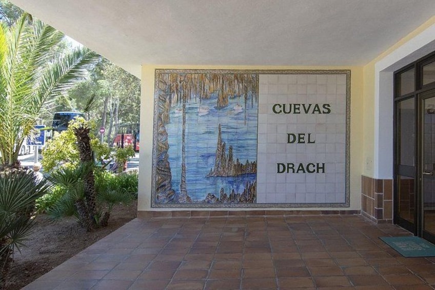 A tiled mural with the text 'CUEVAS DEL DRACH' and a coastal scene. 3