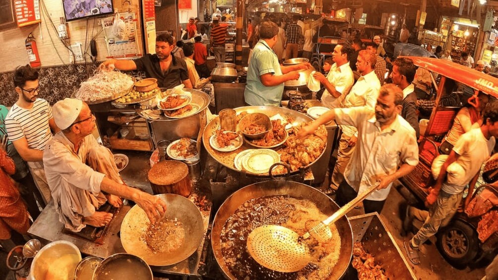 A bustling kitchen with chefs preparing food, large pots, and cooking utensils. 2