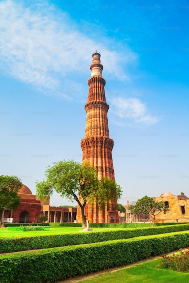 The Qutub Minar, a historic tower with intricate carvings, set against a clear blue sky. 4