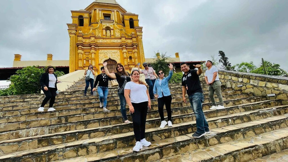 A group of people on stone steps with a historic building in the background. 3
