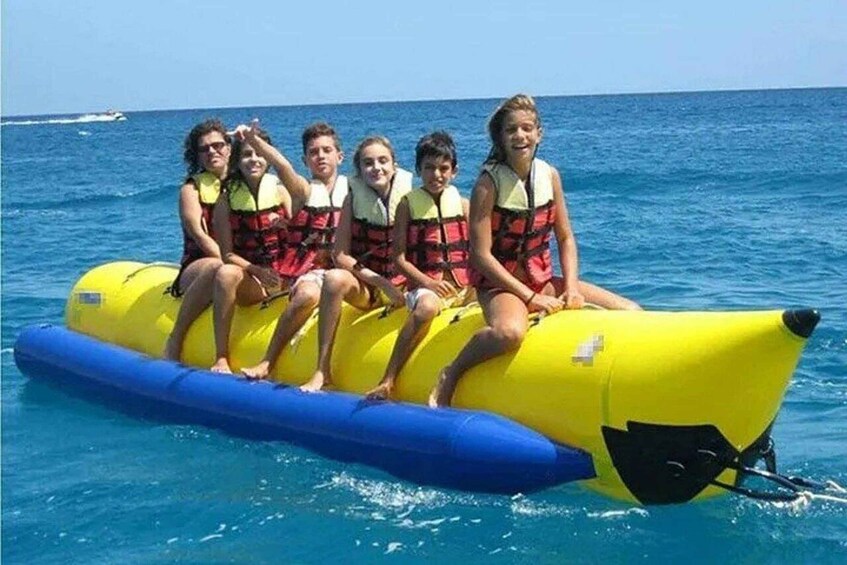 A group of people on a yellow inflatable raft in the ocean. 5