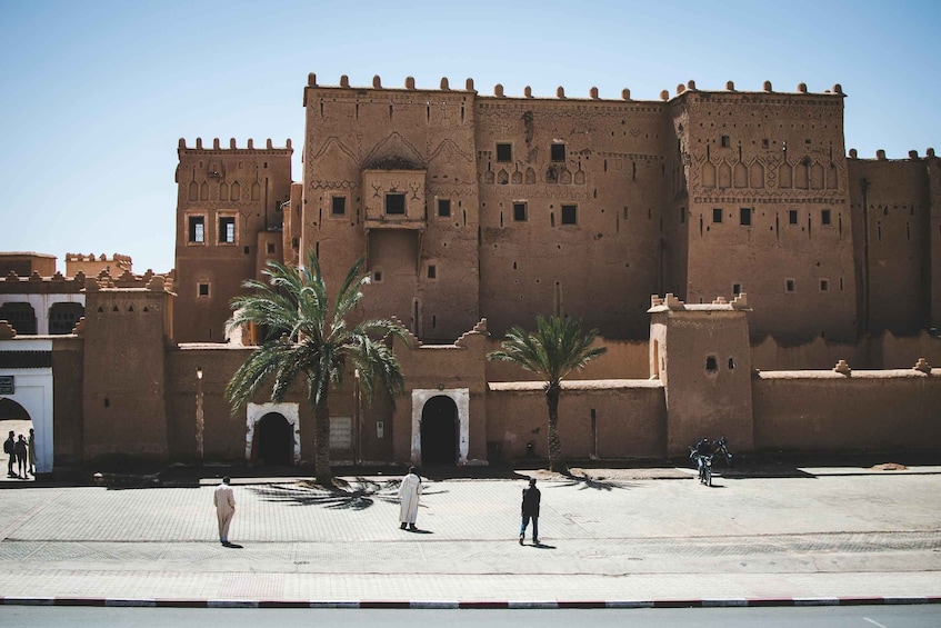 A large, historic building with intricate architectural details and palm trees in front. 4