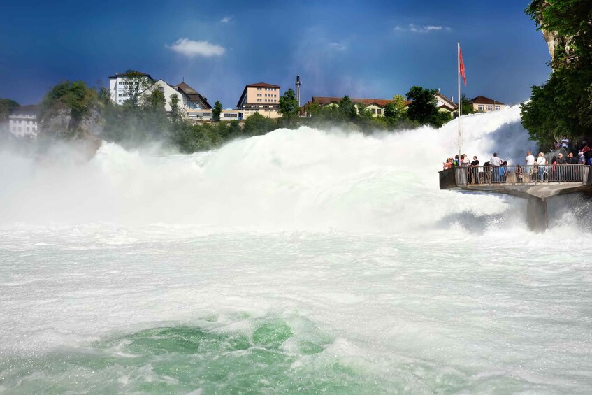 A large waterfall with people watching from a viewing platform. 5
