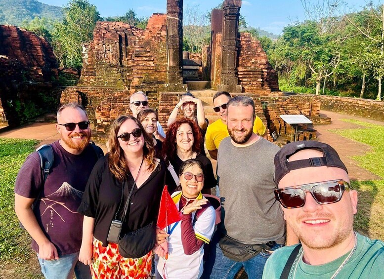 A group of people standing in front of ancient brick ruins with columns. 2