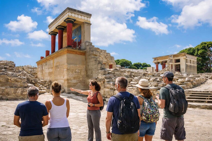 Tourists observing ancient ruins with columns and a temple-like structure. 4