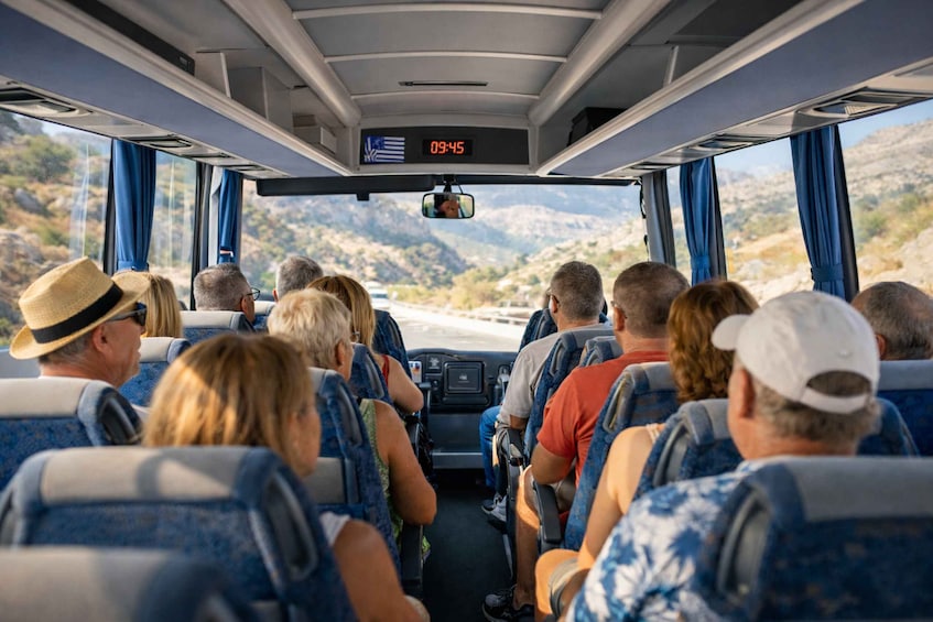 Passengers on a bus with a view of a mountainous landscape through the windows. 3