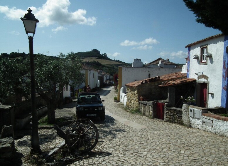 A cobblestone street in a village with traditional buildings, a vintage bicycle, and a lamppost. 2
