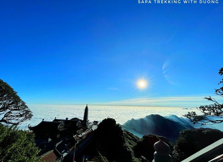 A clear sky, a sun, and a mountainous landscape with traditional buildings. 5