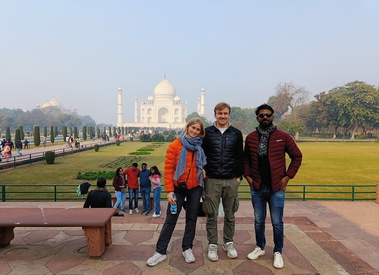 A group of people standing in front of the Taj Mahal. 1
