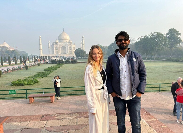 A couple standing in front of the Taj Mahal with the monument in the background. 5