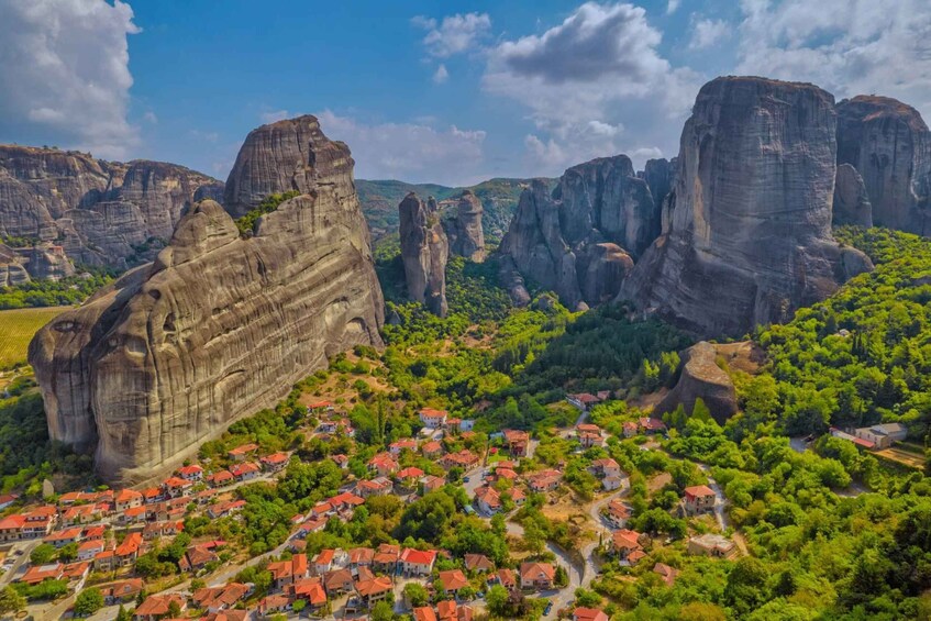 A village nestled among large rock formations with red-roofed houses. 3