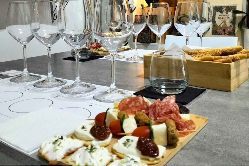 A wine tasting setup with glasses and a charcuterie board. 1