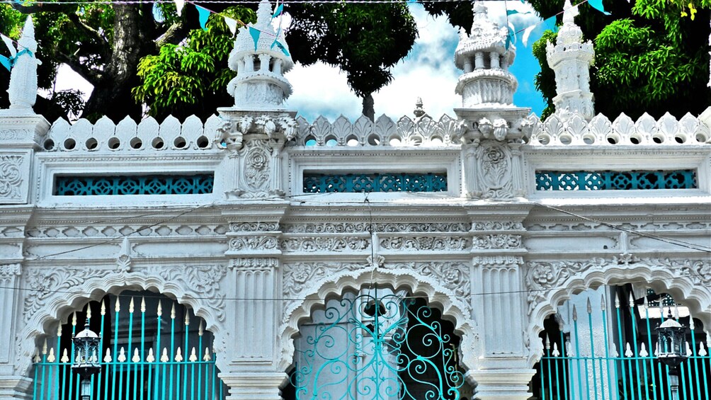 A white ornate building with intricate carvings and blue accents. 5