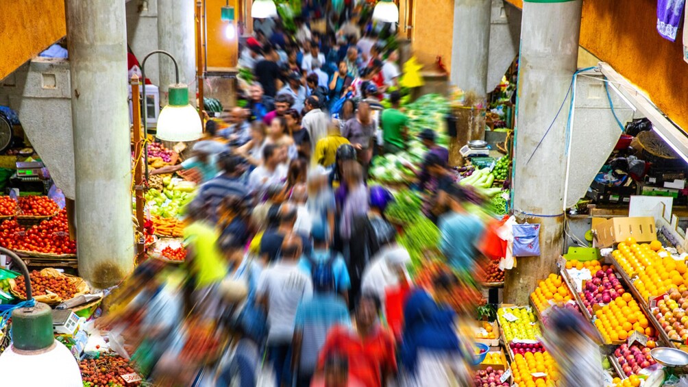 A crowded market with various fruits and vegetables on display. 5