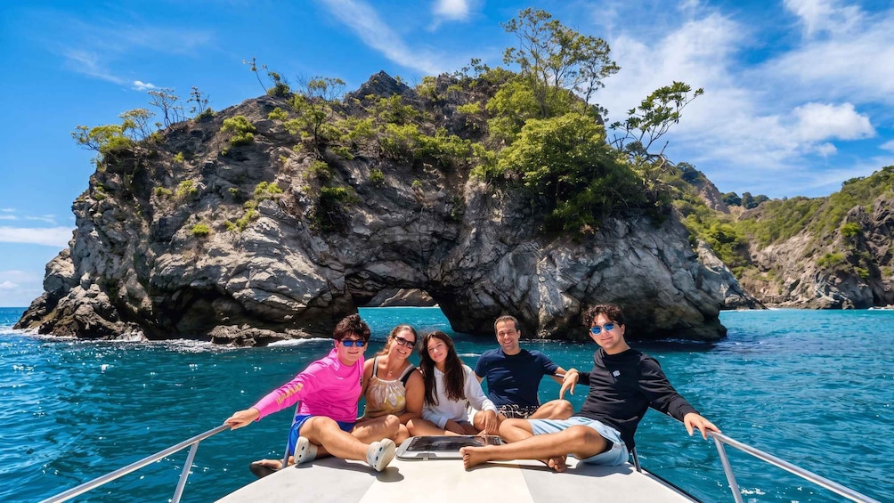 A group of people on a boat with a rocky island in the background. 1