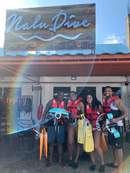 A group of people in front of a building with a sign that reads 'Nalu Dive.' 2