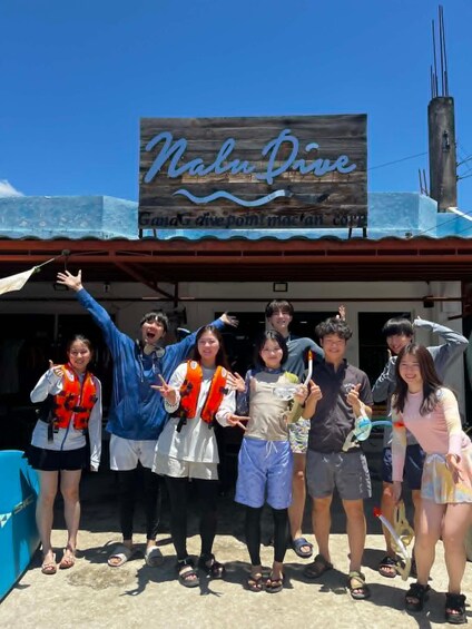 A group of people in front of a building with a sign that reads 'Nalu Dive.' 3