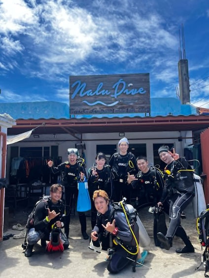 A group of divers in front of a building with a sign reading 'Nalu Dive.' 4